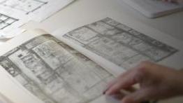 Art History student reviews architectural drawing in a book 